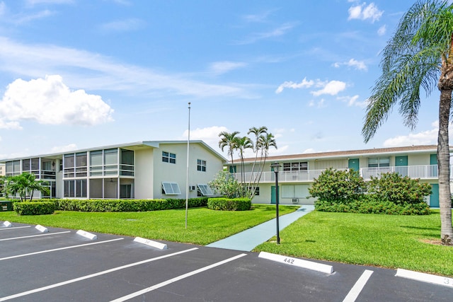 view of parking / parking lot featuring a yard