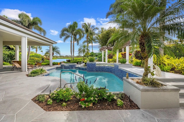 view of pool featuring a water view, a patio area, and an in ground hot tub