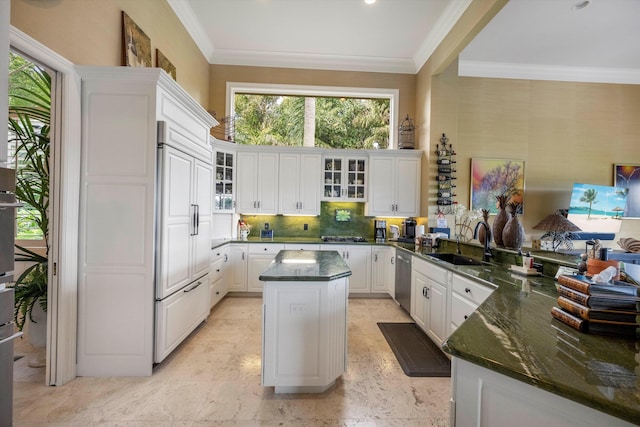 kitchen featuring sink, a kitchen island, paneled built in fridge, white cabinets, and crown molding