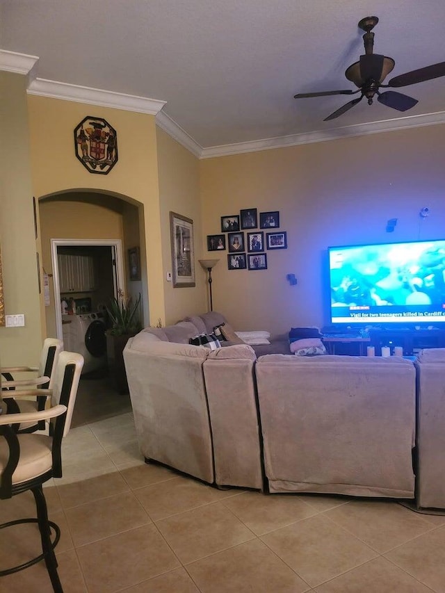 living room with washer / clothes dryer, ceiling fan, light tile patterned floors, and ornamental molding