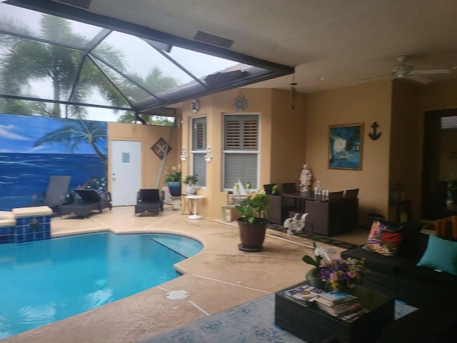 view of swimming pool with glass enclosure, ceiling fan, and a patio area