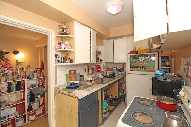 kitchen featuring a sink, white cabinets, light countertops, open shelves, and tasteful backsplash