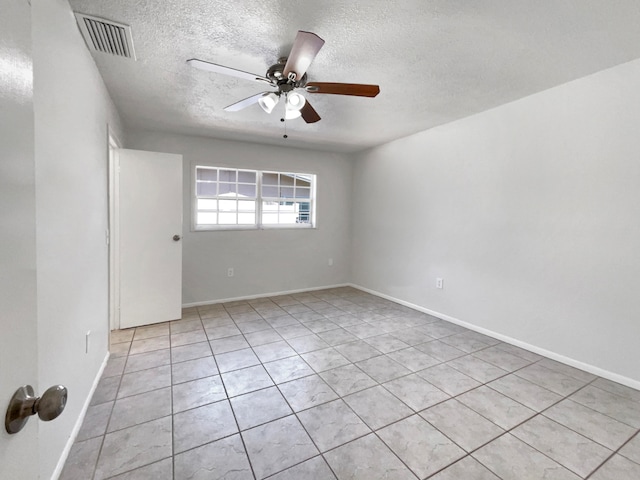 unfurnished room featuring ceiling fan, light tile patterned floors, and a textured ceiling