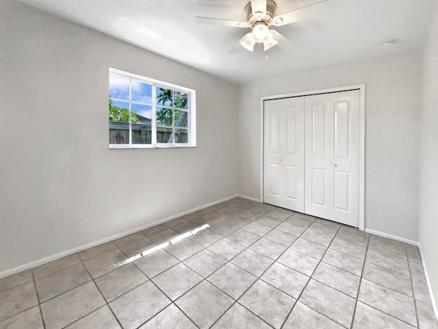 unfurnished bedroom featuring light tile patterned floors, ceiling fan, and a closet