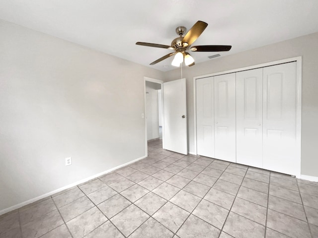 unfurnished bedroom featuring light tile patterned floors, ceiling fan, and a closet