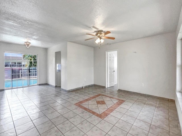 tiled spare room featuring ceiling fan and a textured ceiling