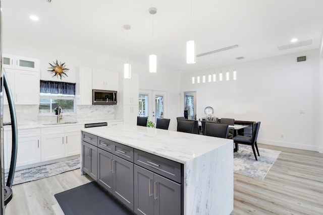 kitchen with gray cabinets, pendant lighting, white cabinetry, and sink