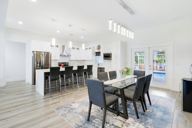 dining space featuring sink, french doors, and light hardwood / wood-style floors