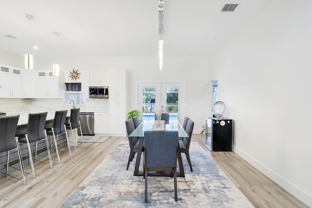 dining room with french doors and light hardwood / wood-style floors