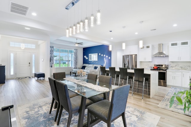 dining area featuring light wood-type flooring and ceiling fan