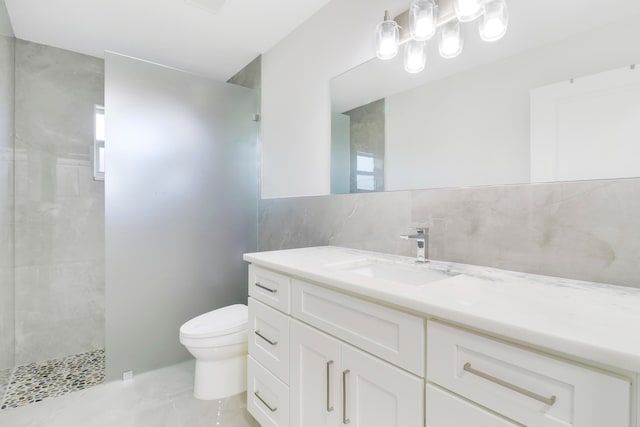 bathroom featuring tiled shower, toilet, tasteful backsplash, and vanity