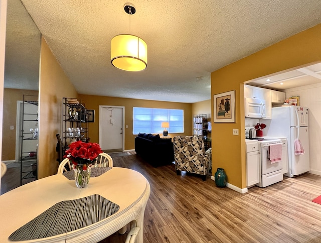 dining room featuring light hardwood / wood-style floors and a textured ceiling