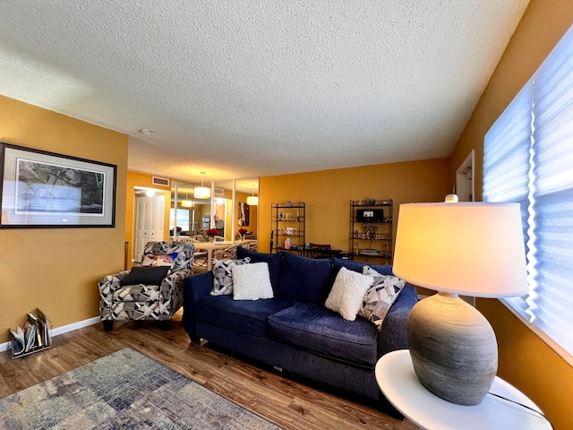 living room with dark wood-type flooring and a textured ceiling