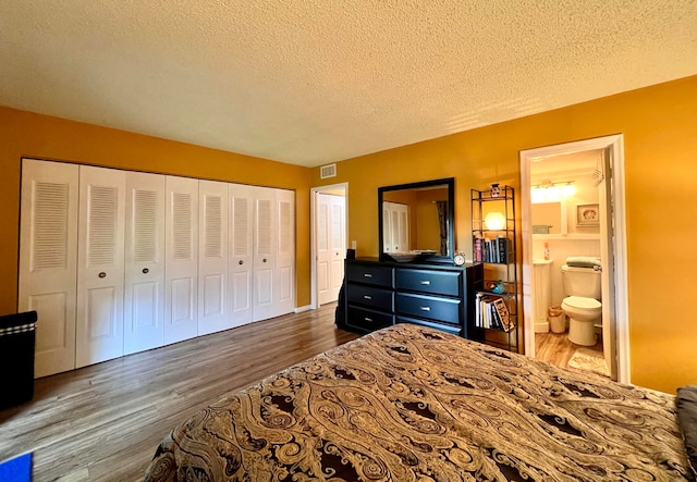 bedroom featuring ensuite bathroom, a closet, dark hardwood / wood-style floors, and a textured ceiling