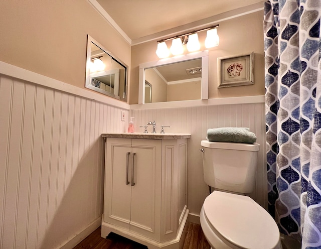 bathroom with crown molding, hardwood / wood-style flooring, vanity, and toilet