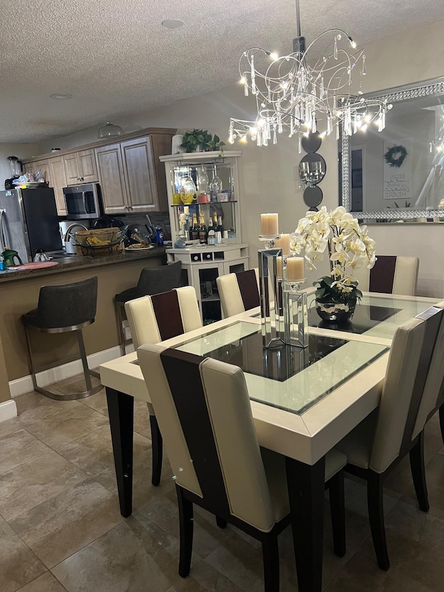 dining area featuring an inviting chandelier and a textured ceiling