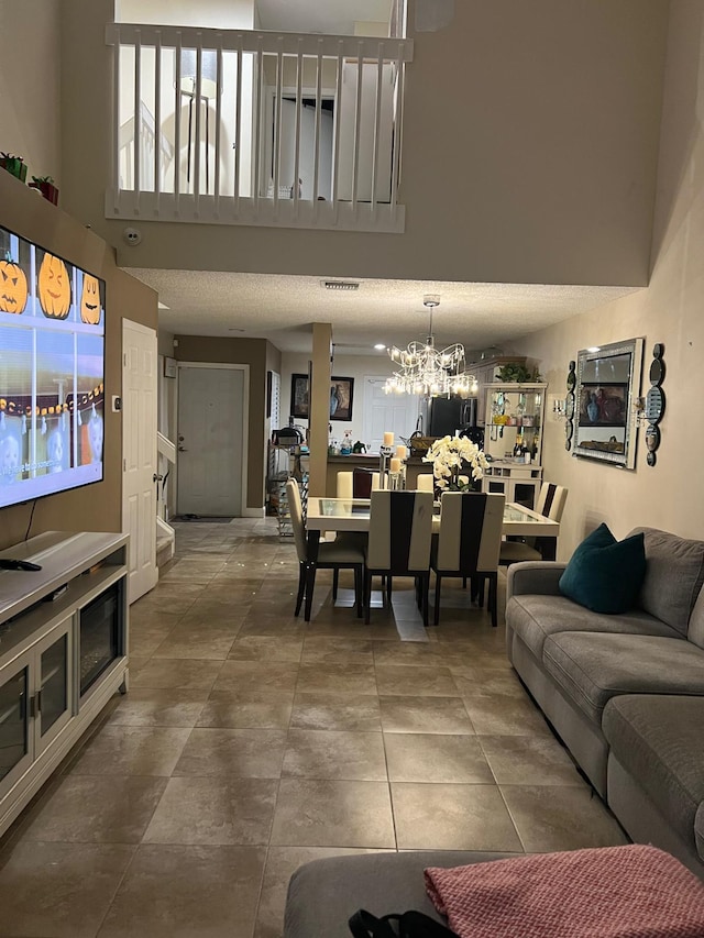 living room featuring a textured ceiling, a notable chandelier, and tile patterned flooring