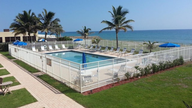 view of pool featuring a water view and a lawn