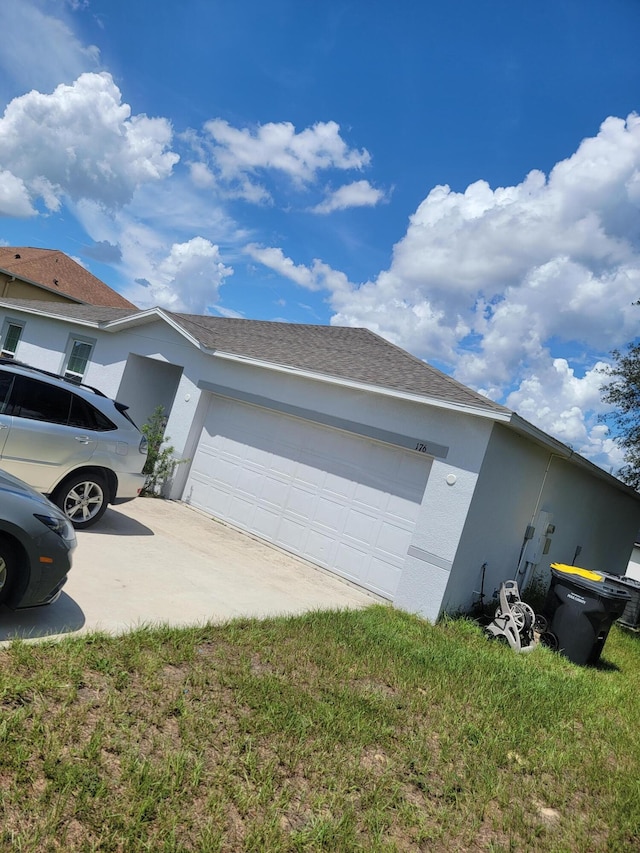 view of home's exterior with a garage and a lawn