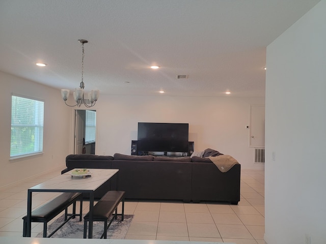 tiled living room featuring a textured ceiling and a chandelier