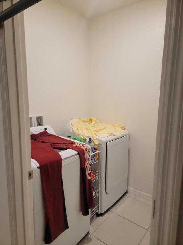 laundry area with light tile patterned floors and washing machine and clothes dryer