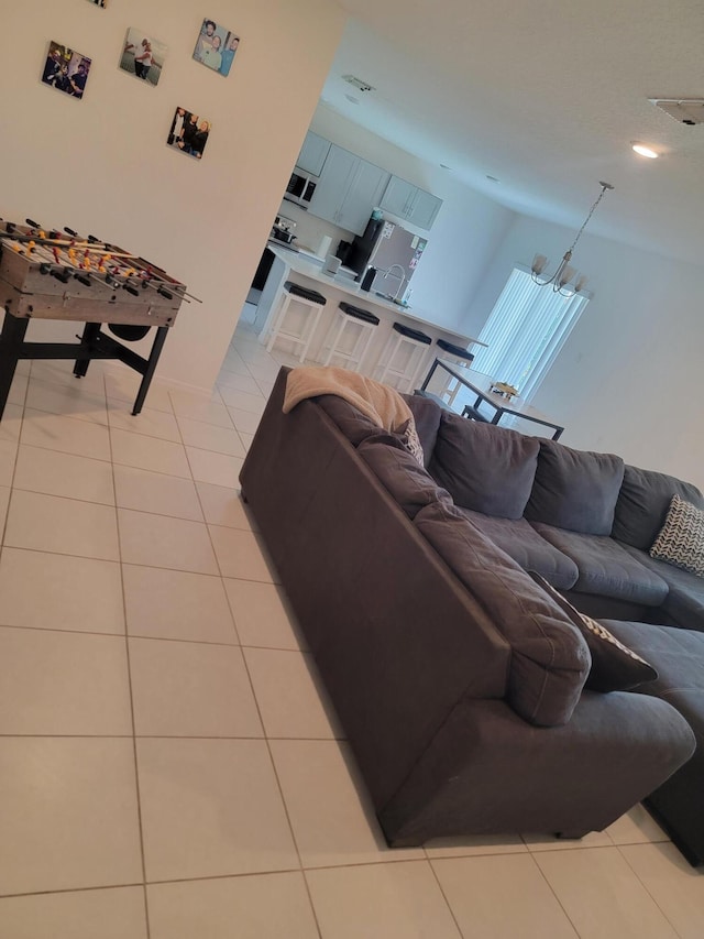 tiled living room featuring a chandelier