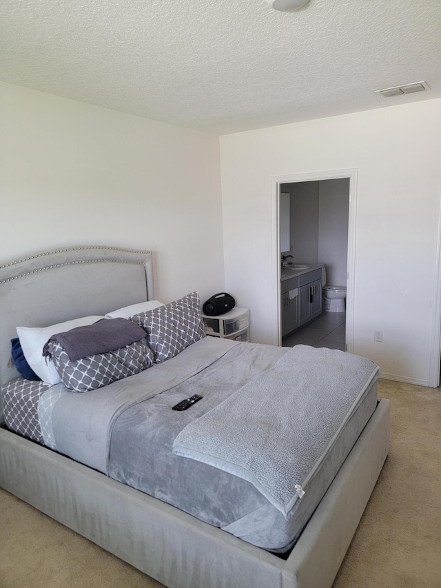 carpeted bedroom with sink and a textured ceiling