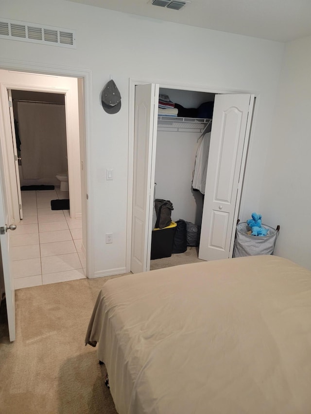 bedroom with light colored carpet and a closet