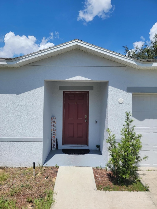 view of exterior entry with a garage