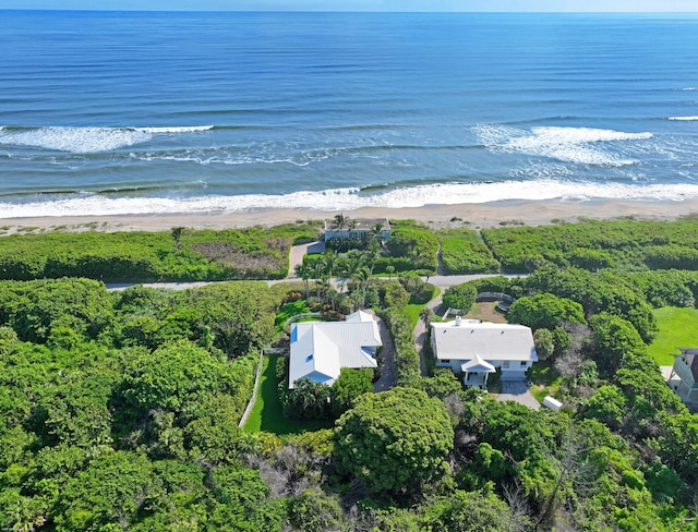 birds eye view of property with a water view and a beach view