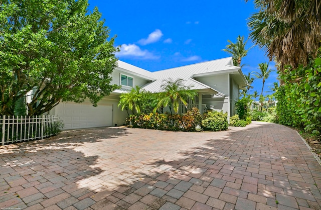 view of property hidden behind natural elements featuring a garage