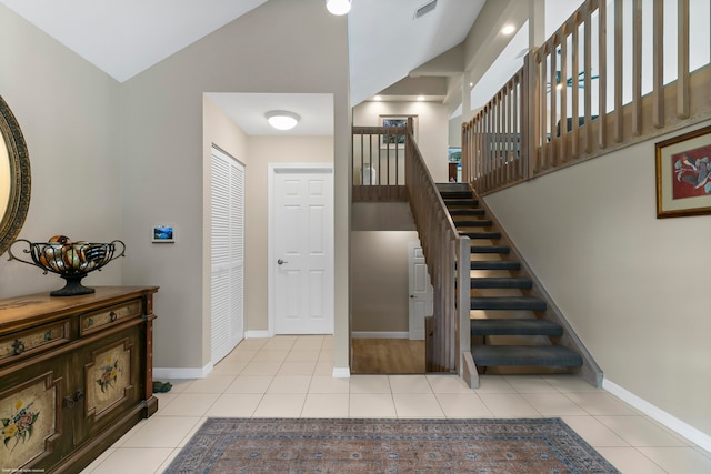 stairs featuring lofted ceiling and tile patterned flooring