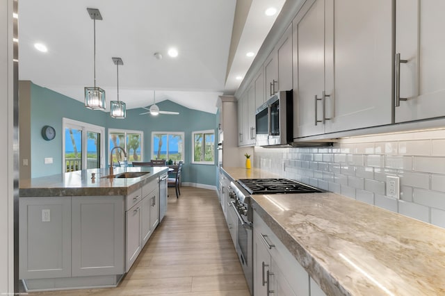 kitchen featuring sink, ceiling fan, stainless steel appliances, lofted ceiling, and pendant lighting