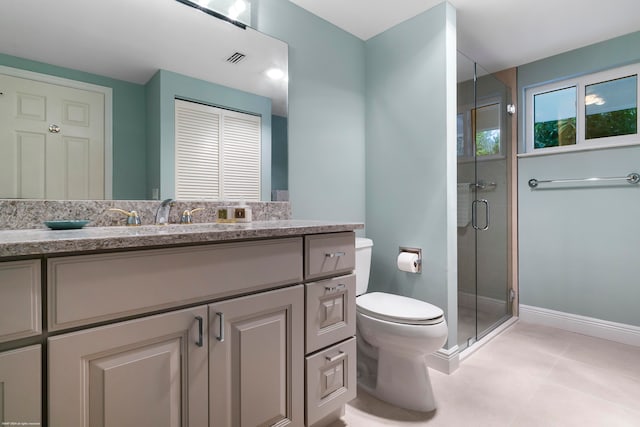 bathroom featuring vanity, a shower with shower door, toilet, and tile patterned floors