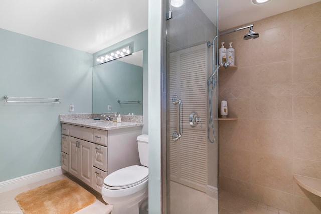 bathroom featuring vanity, tiled shower, toilet, and tile patterned flooring