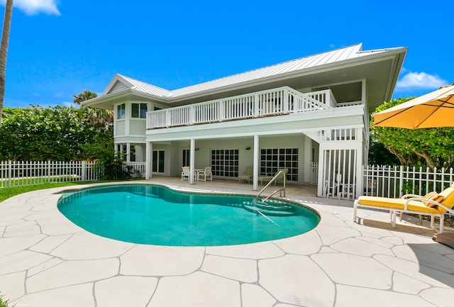 rear view of house featuring a patio area and a fenced in pool