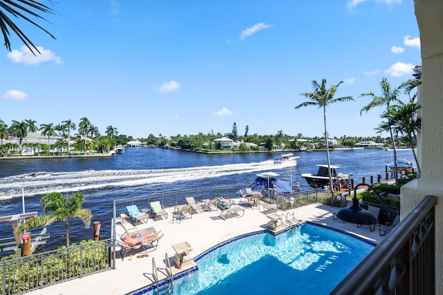 view of swimming pool with a water view and a patio