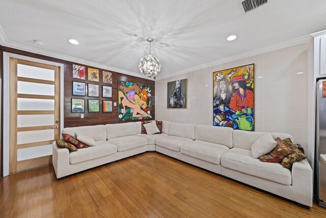 living area featuring a chandelier, recessed lighting, light wood finished floors, and ornamental molding