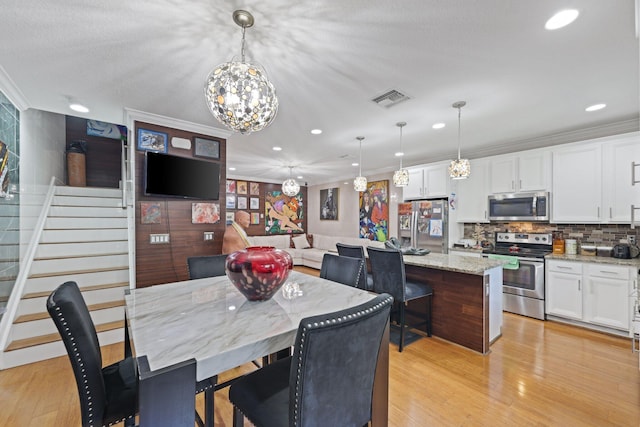 dining area with ornamental molding, stairs, recessed lighting, light wood-style floors, and a chandelier