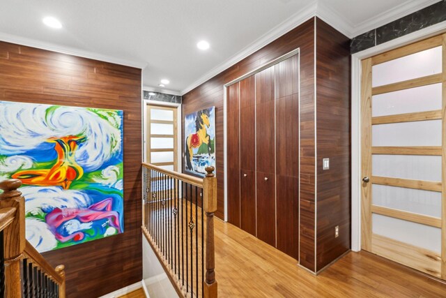 corridor featuring crown molding, wood-type flooring, and wood walls