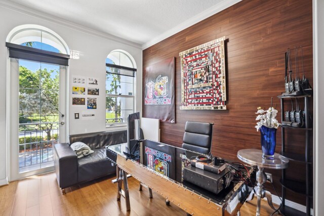 office with ornamental molding, hardwood / wood-style floors, and wooden walls