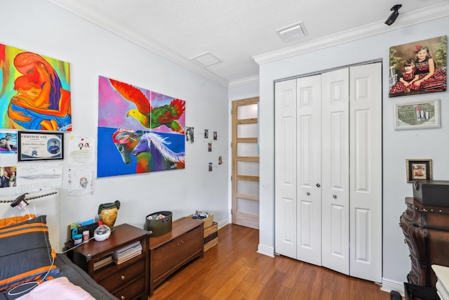 bedroom featuring ornamental molding, wood finished floors, a closet, and baseboards