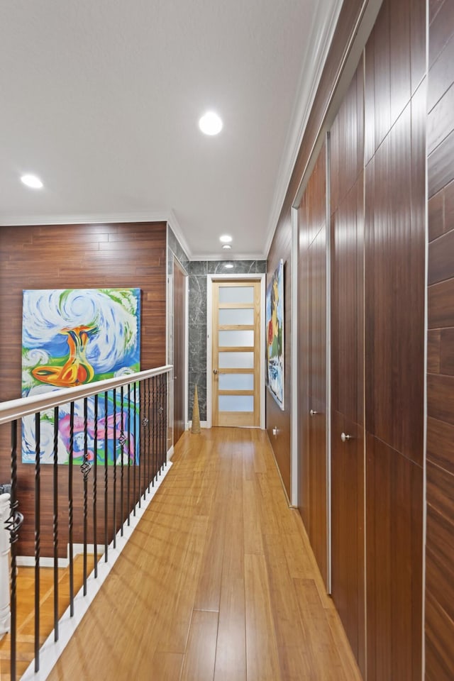corridor with crown molding, light wood-style floors, and recessed lighting