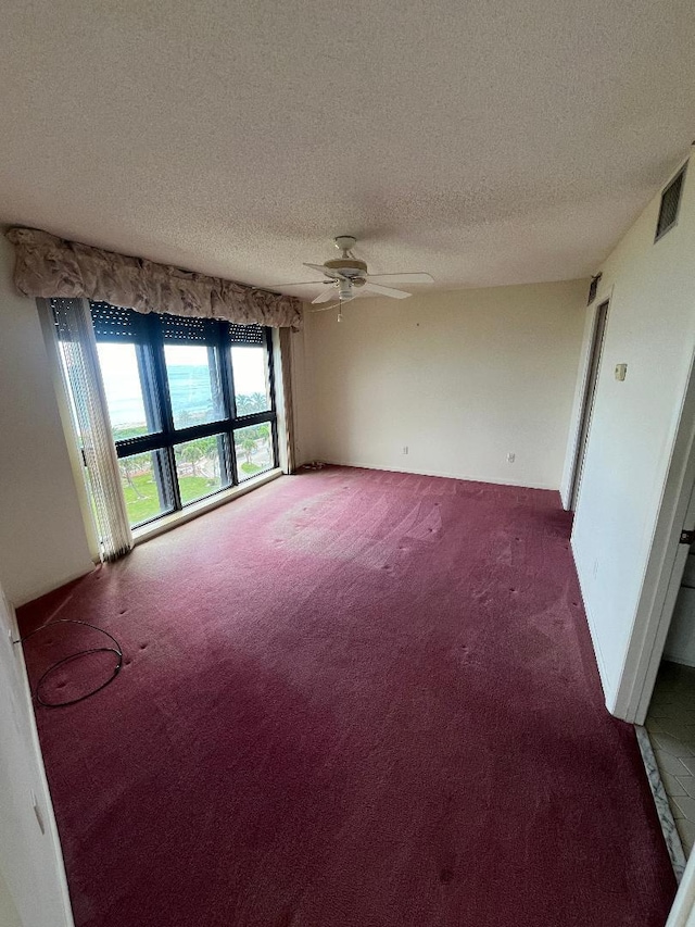 carpeted empty room featuring a textured ceiling and ceiling fan