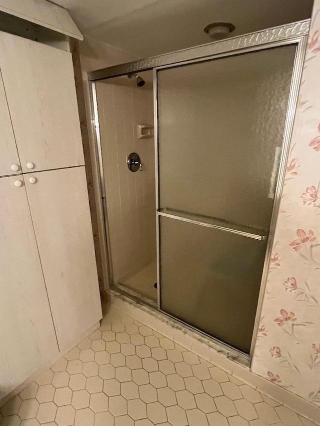 bathroom with tile patterned flooring and a shower with door