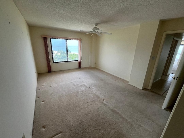 unfurnished bedroom with light colored carpet, ceiling fan, and a textured ceiling