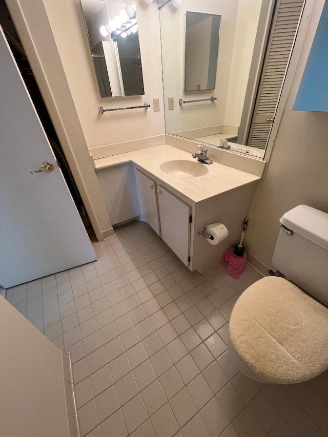 bathroom featuring tile patterned flooring, vanity, and toilet