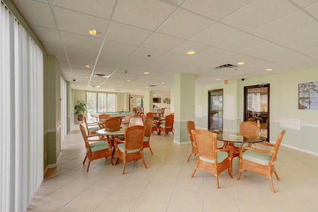 dining space featuring a paneled ceiling and light tile patterned floors