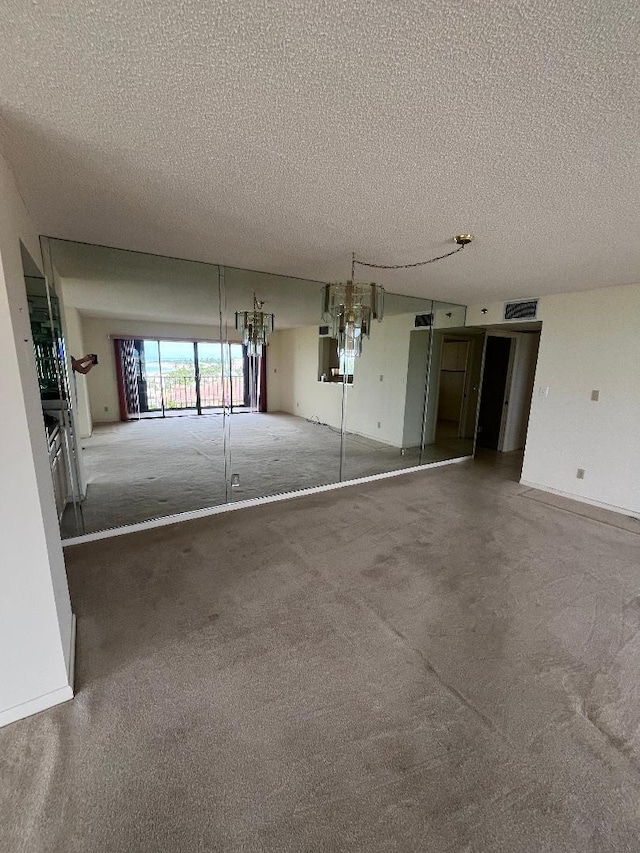 interior space featuring carpet, a notable chandelier, and a textured ceiling