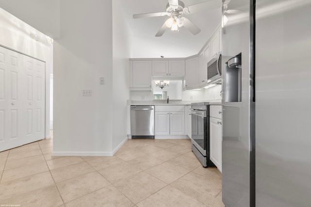 kitchen with ceiling fan, appliances with stainless steel finishes, light tile patterned flooring, and white cabinets